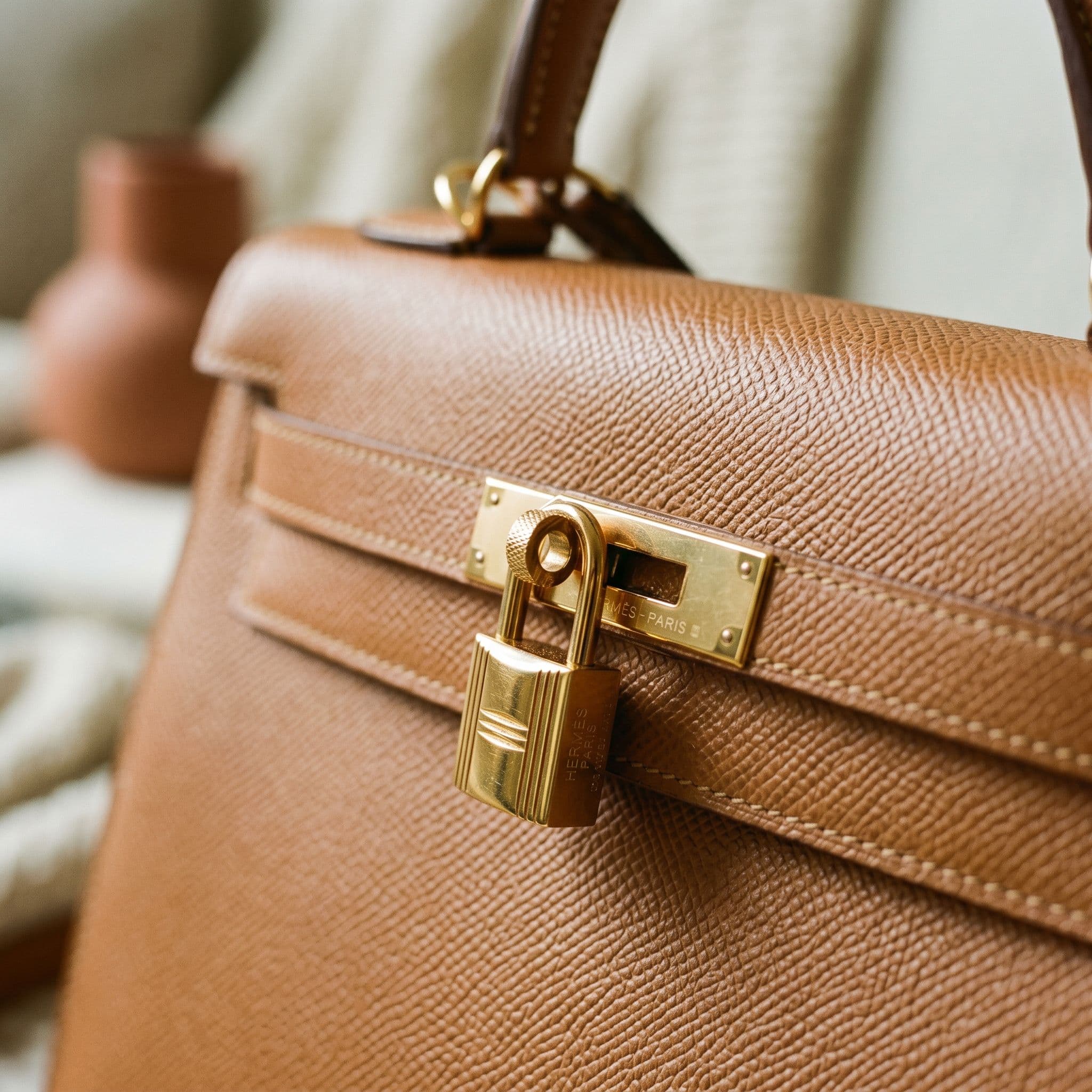 Macro of engraved gold clasp and buckle on tan leather.